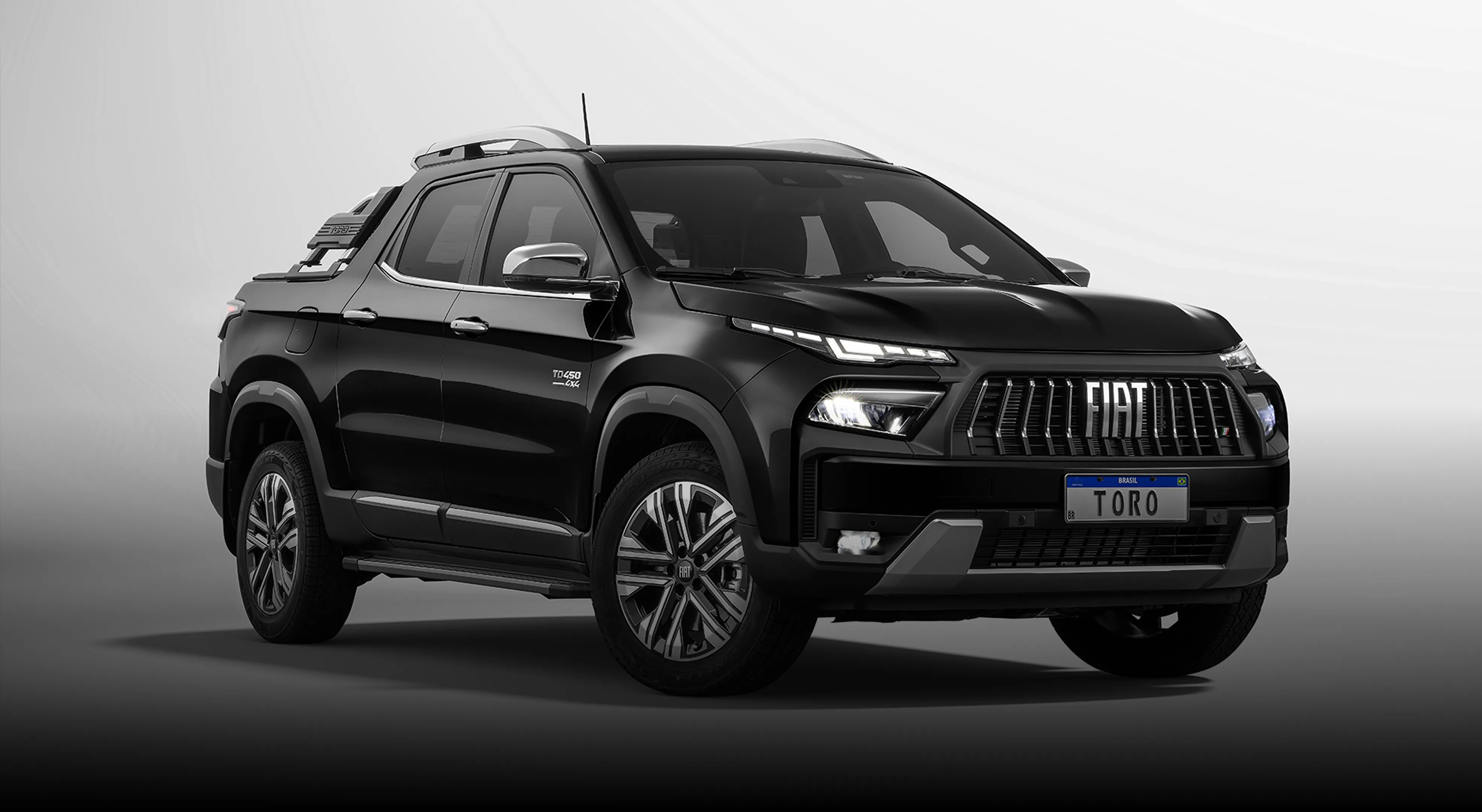 Fiat Toro preta com grade dianteira, faróis em LED acesos, rodas de liga-leve, estribo lateral e placa Toro.