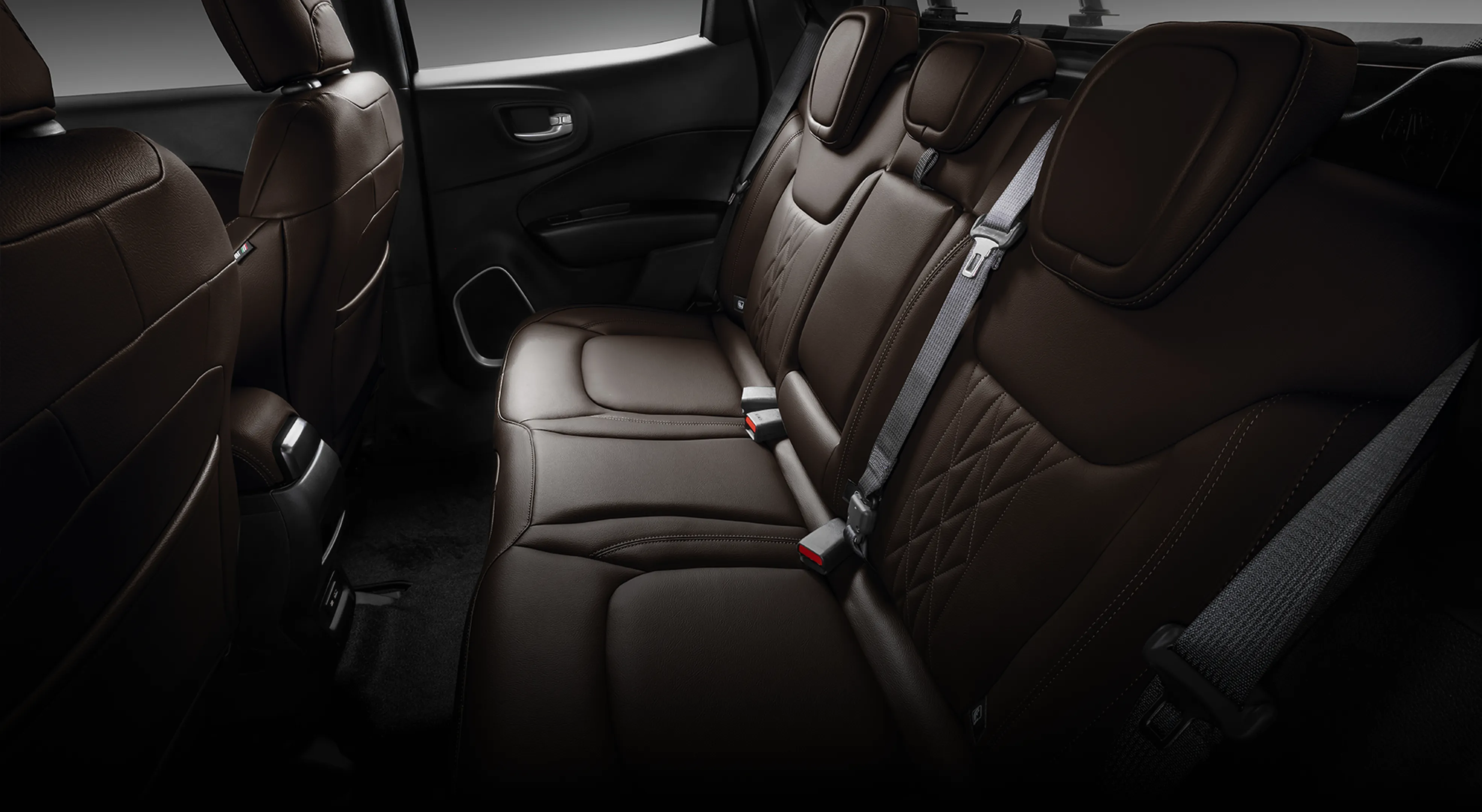 Interior da Fiat Toro com banco traseiro revestido em couro marrom e encostos com costuras aparentes.