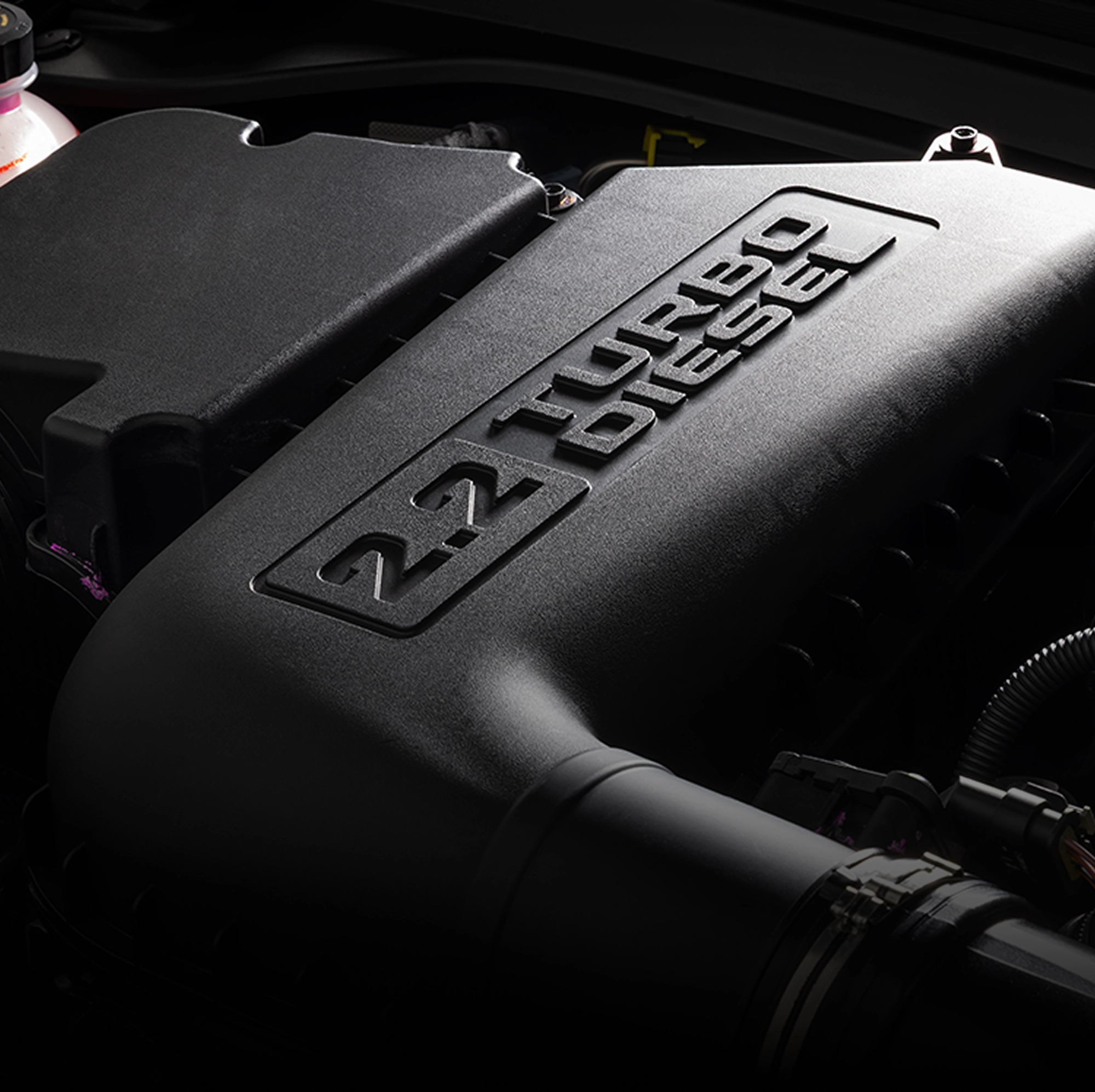 Motor da Fiat Toro com tampa superior identificada 2.2 Turbodiesel e alguns componentes à mostra.